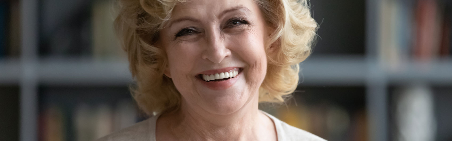 Happy elderly woman after having dental implant treatment